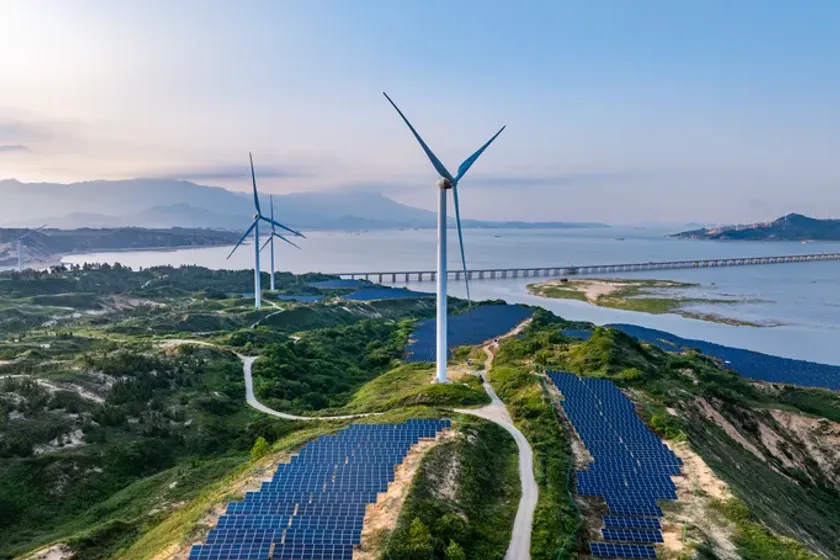Wind turbines and solar panels on a coastal ridge